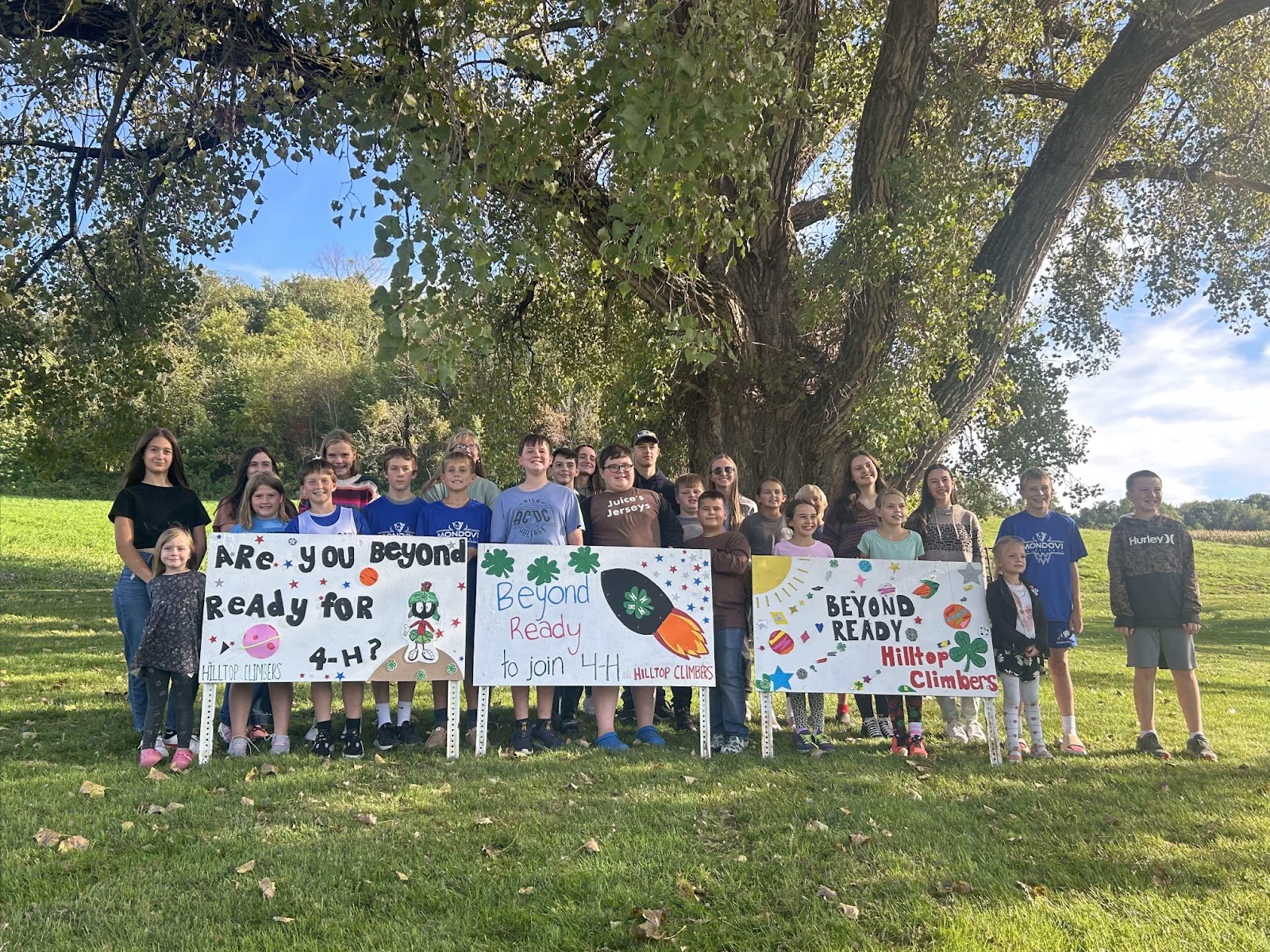 4-H members standing in front of National 4-H week displays