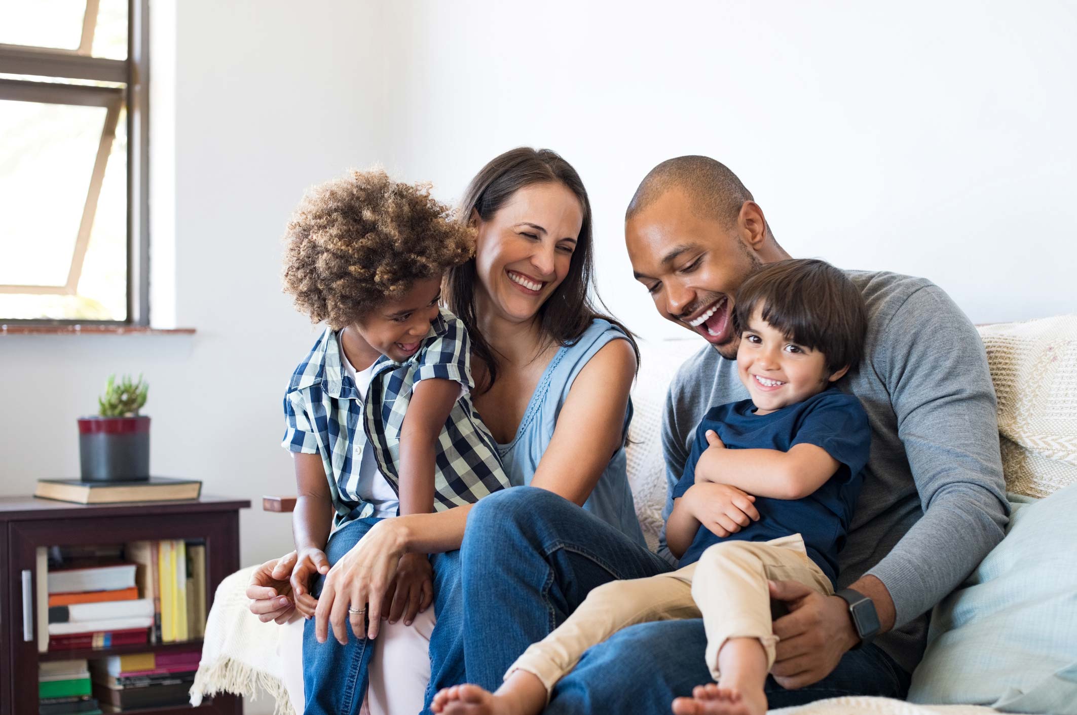 picture of family of four smiling at each other