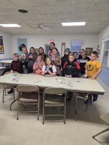 Cheerful Workers Create Foil-Wrapped Hearts at February Meeting